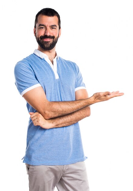 Hombre con la camisa azul que presenta algo