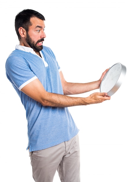 Hombre con la camisa azul que sostiene el reloj