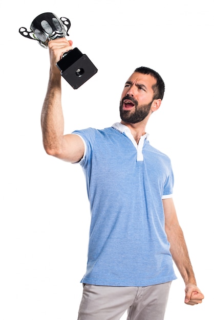 Foto gratuita hombre con la camisa azul que sostiene un trofeo