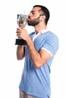 Foto gratuita hombre con la camisa azul que sostiene un trofeo