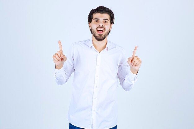 Hombre con camisa blanca apuntando al revés.