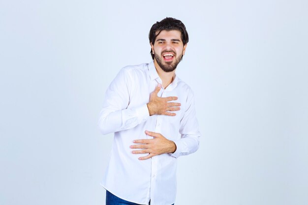 Hombre con una camisa blanca apuntando a sí mismo