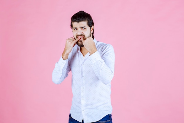 Hombre con una camisa blanca batiendo con los dedos.