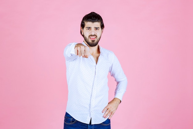 El hombre con una camisa blanca se da cuenta y señala a la persona que va delante.