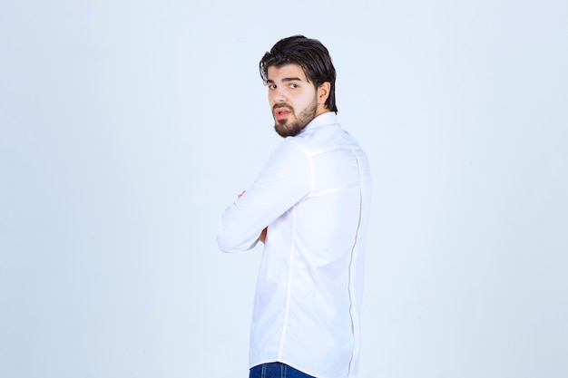 Hombre con una camisa blanca dando poses neutrales