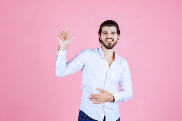 Hombre con una camisa blanca dando poses positivas y sonrientes.