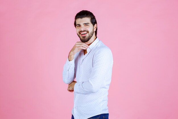 Hombre con una camisa blanca dando poses positivas y sonrientes.
