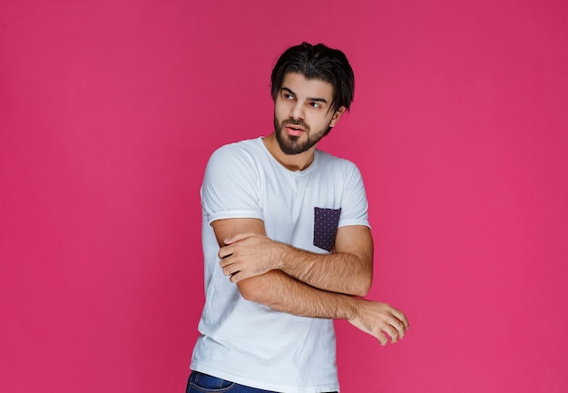 Hombre con camisa blanca dando poses seductoras.