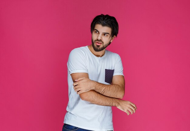 Hombre con camisa blanca dando poses seductoras.