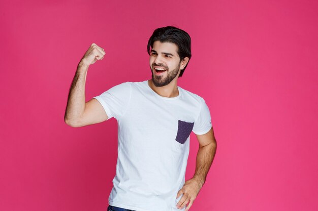 Hombre con camisa blanca dando poses seductoras.