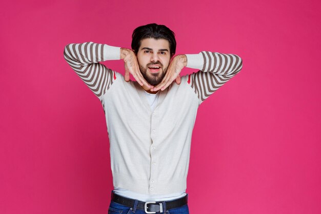 Hombre con camisa blanca haciendo muecas y gestos.