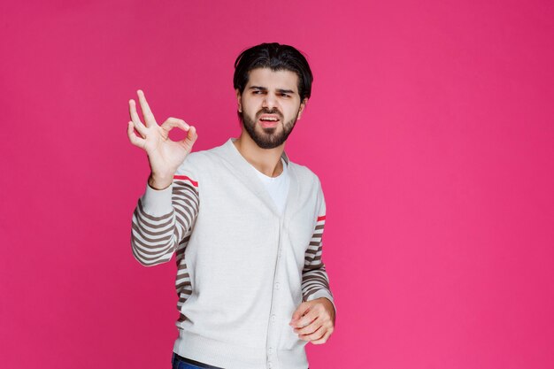 Hombre con camisa blanca haciendo signo de mano bien o perfección.