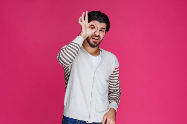 Hombre con camisa blanca haciendo signo de mano bien o perfección.