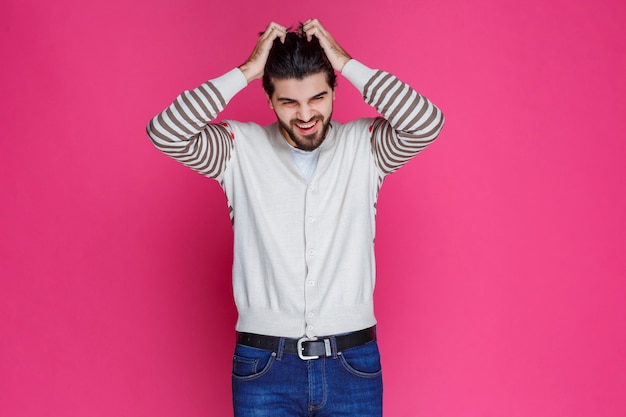 Foto gratuita el hombre con camisa blanca se lleva la mano a la cabeza como si estuviera pensando profundamente y tratando de recordar