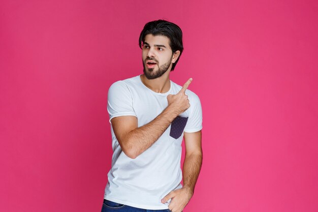 Hombre con camisa blanca mostrando algo arriba.