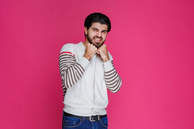 Hombre con camisa blanca mostrando sus puños y poder.