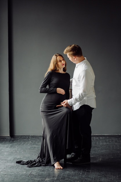 Hombre con camisa blanca y mujer con vestido negro Foto de embarazo