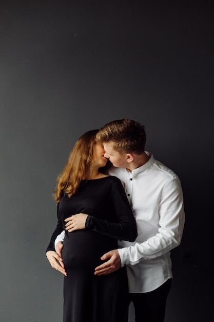 Hombre con camisa blanca y mujer con vestido negro Foto de embarazo