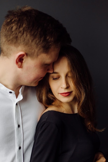 Hombre con camisa blanca y mujer con vestido negro Foto de embarazo