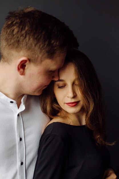 Hombre con camisa blanca y mujer con vestido negro Foto de embarazo