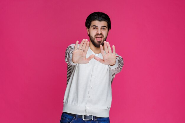 Hombre con camisa blanca parando o previniendo algo.