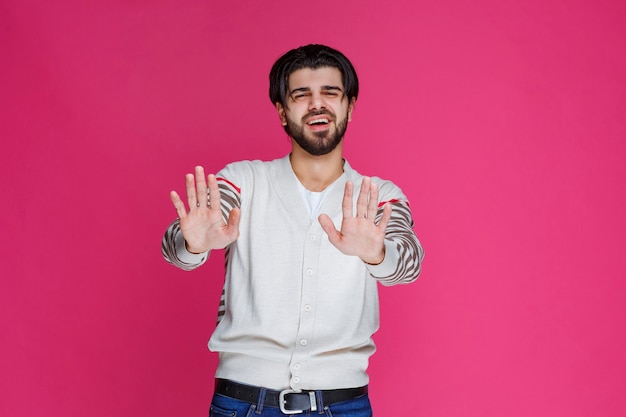 Hombre con camisa blanca parando o previniendo algo.