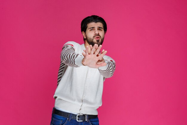 Hombre con camisa blanca parando o previniendo algo.