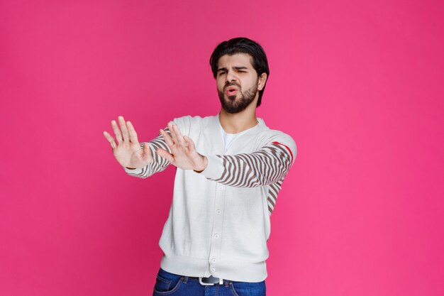 Hombre con camisa blanca parando o previniendo algo.