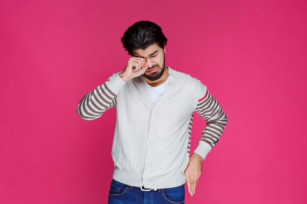 El hombre con camisa blanca parece exhausto y somnoliento.