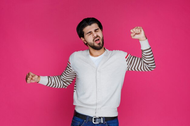 El hombre con camisa blanca parece exhausto y somnoliento.