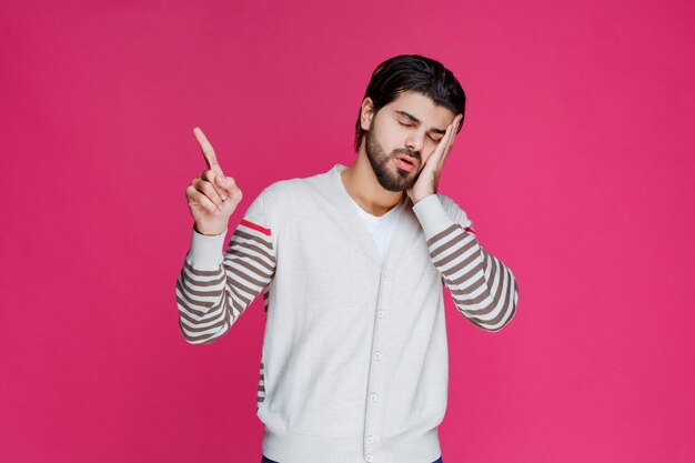 El hombre con camisa blanca parece exhausto y somnoliento.