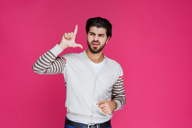 El hombre con camisa blanca parece pensativo y confundido.