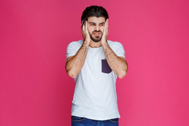 El hombre con camisa blanca parece triste y decepcionado.