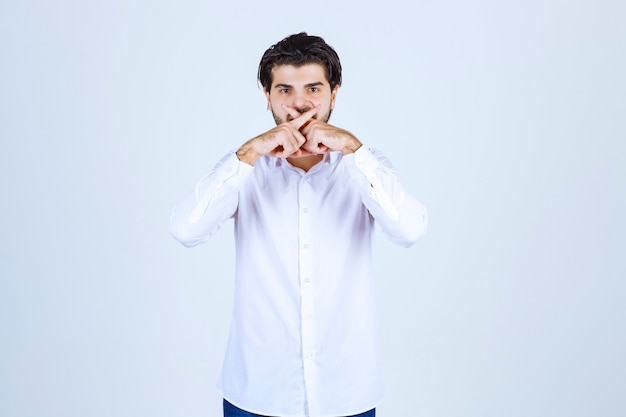 Foto gratuita hombre con camisa blanca pidiendo silencio.