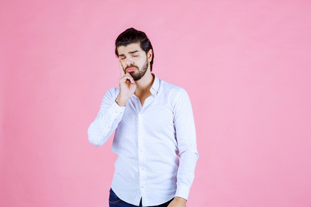 El hombre con una camisa blanca piensa o parece pensativo.