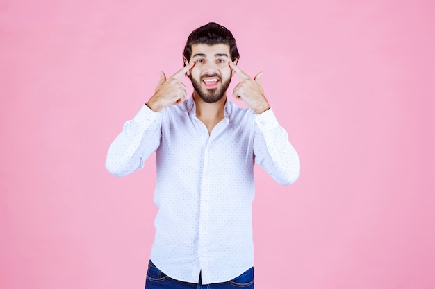 El hombre con una camisa blanca piensa o parece pensativo.