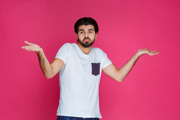 Hombre con camisa blanca que demuestra que no tiene idea sobre el tema.