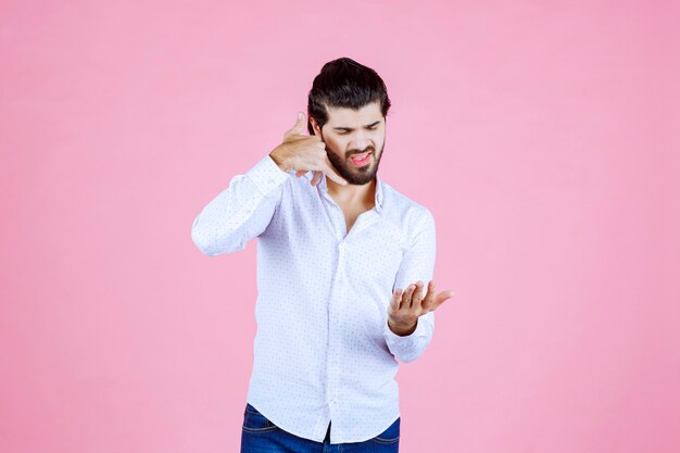 Hombre con una camisa blanca que muestra el distintivo de llamada.