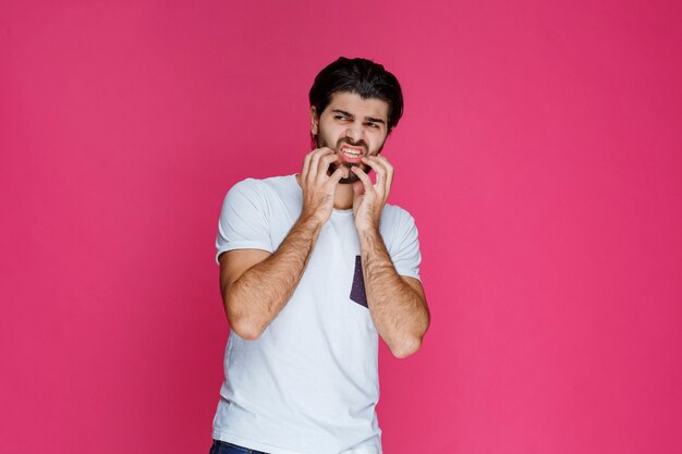 El hombre con camisa blanca se siente nervioso por algo.