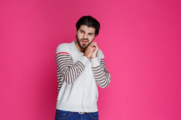 El hombre con camisa blanca se siente positivo y sonríe.