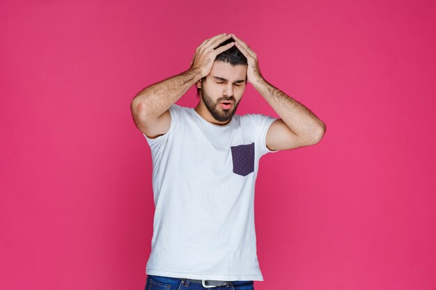 El hombre con camisa blanca siente sueño y cierra los ojos.