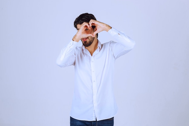 Hombre con camisa blanca soplando amor a sus fans.