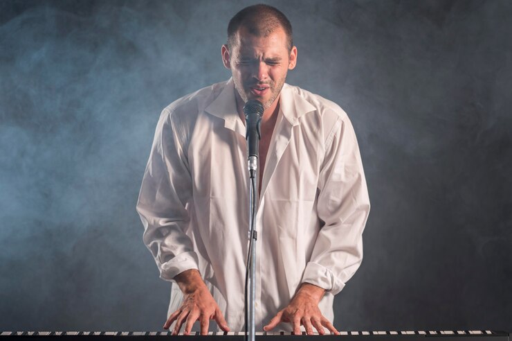 Foto gratuito hombre de camisa blanca tocando teclados y canta efecto humo