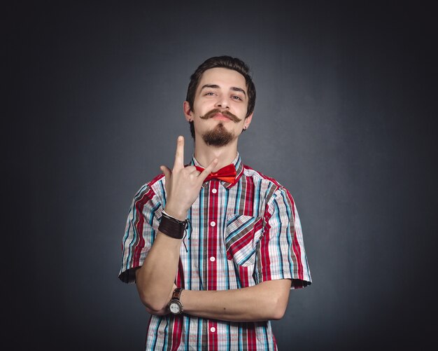 Hombre en camisa a cuadros y pajarita en el estudio