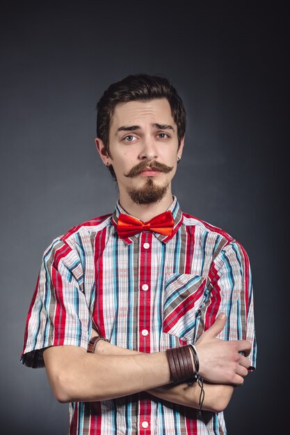 Hombre en camisa a cuadros y pajarita en el estudio