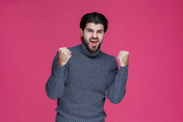 El hombre con camisa gris parece seguro de sí mismo.