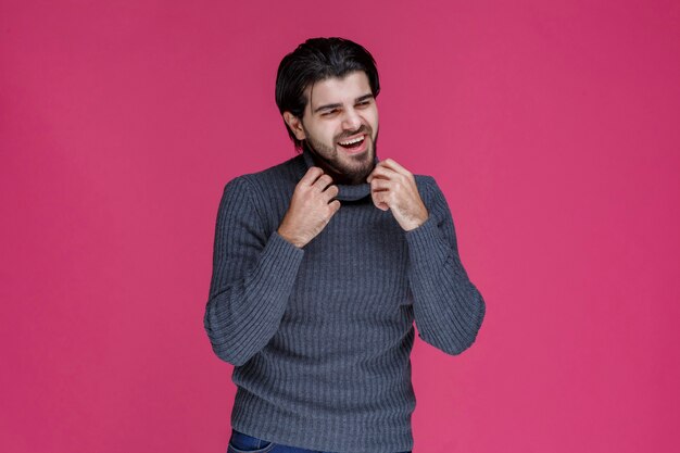 El hombre con camisa gris parece seguro de sí mismo.