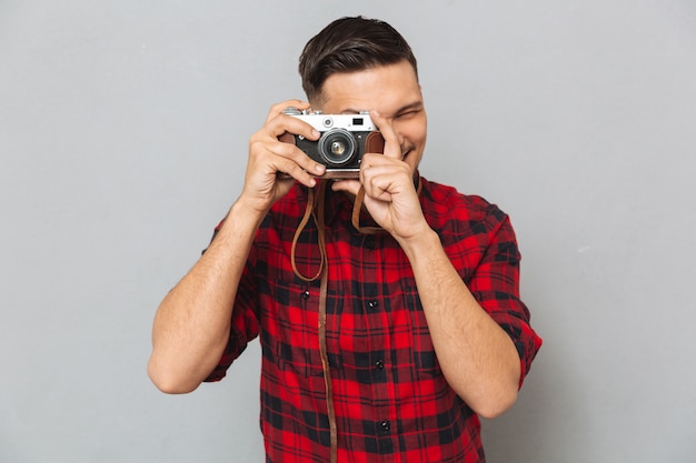 Foto gratuita hombre en camisa haciendo foto en cámara retro