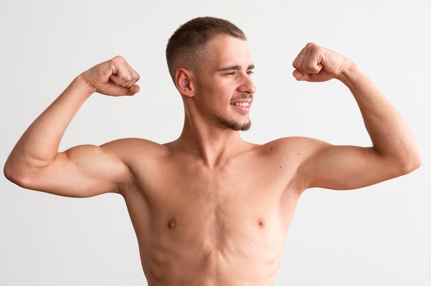 Hombre sin camisa mostrando sus bíceps