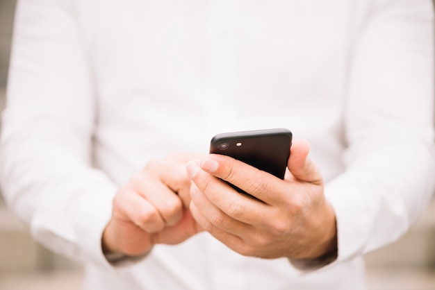 Foto gratuita hombre en camisa de navegación en el teléfono